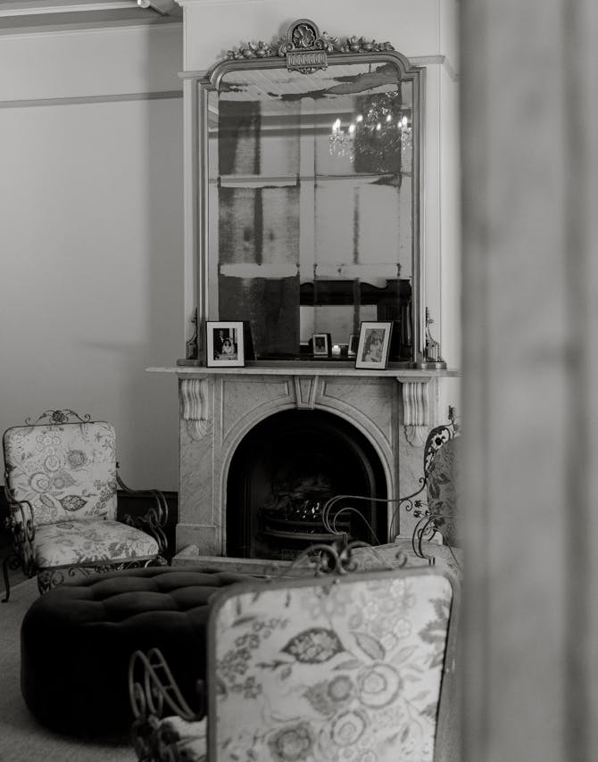 black and white photograph of a room within the gabbinbar wedding venue with a characterful fireplace and mirror