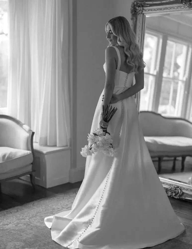 Bride with long white dress with buttons down back