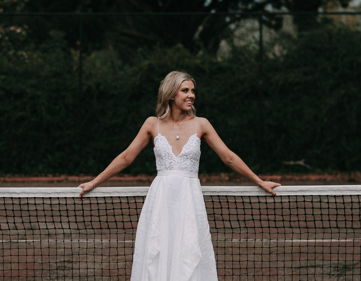 Bride poses on tennis court