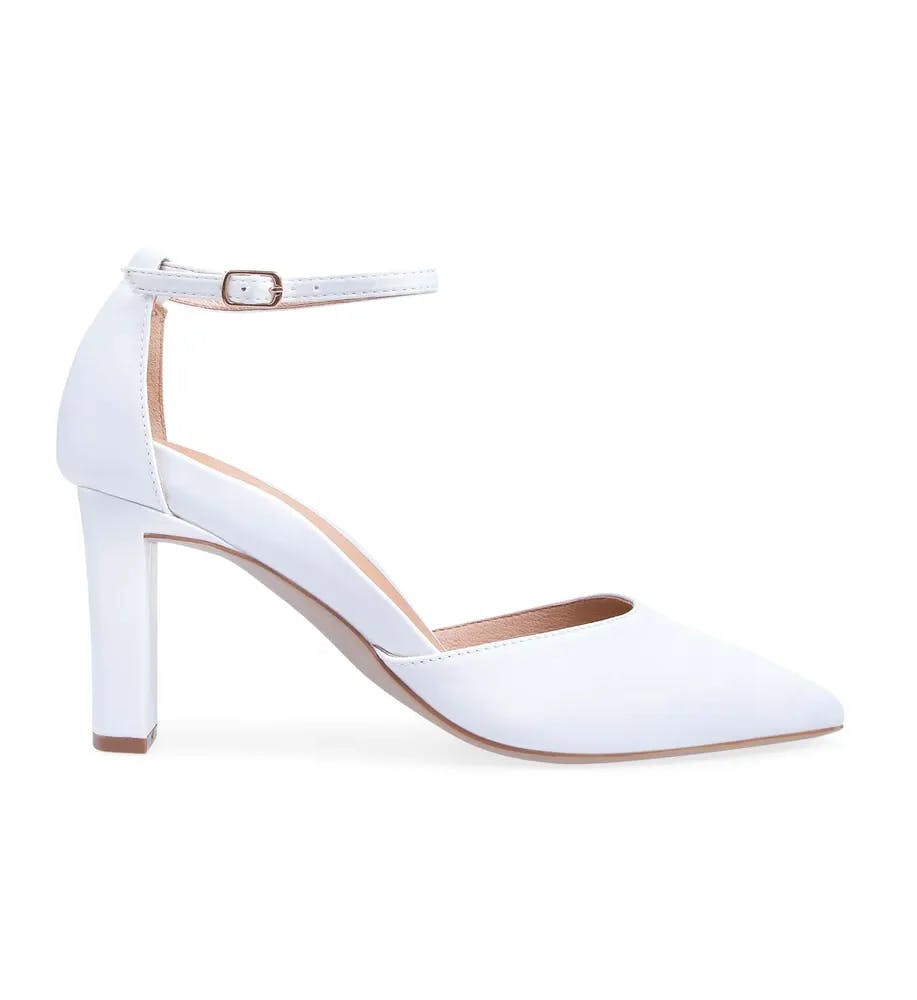 A side view of a single white high-heeled women's shoe with a pointed toe and an ankle strap secured by a small buckle. The heel is block-shaped, and the interior lining appears light brown. The shoe has a sleek, minimalist design.