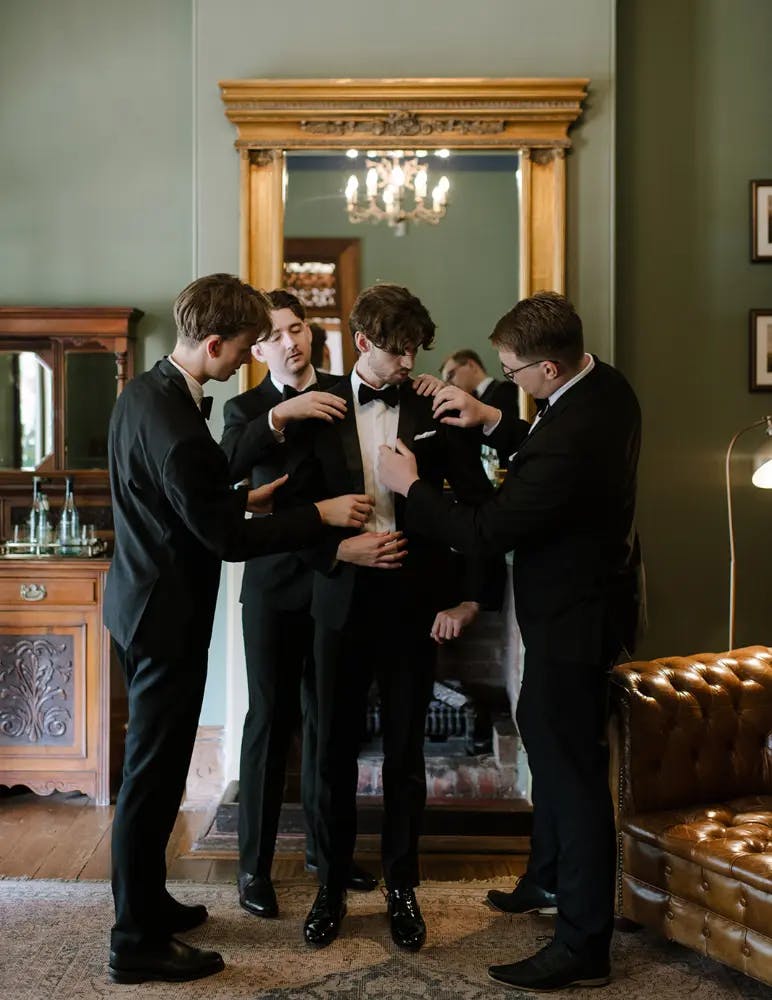 Groom and groomsmen prepare for ceremony in the library