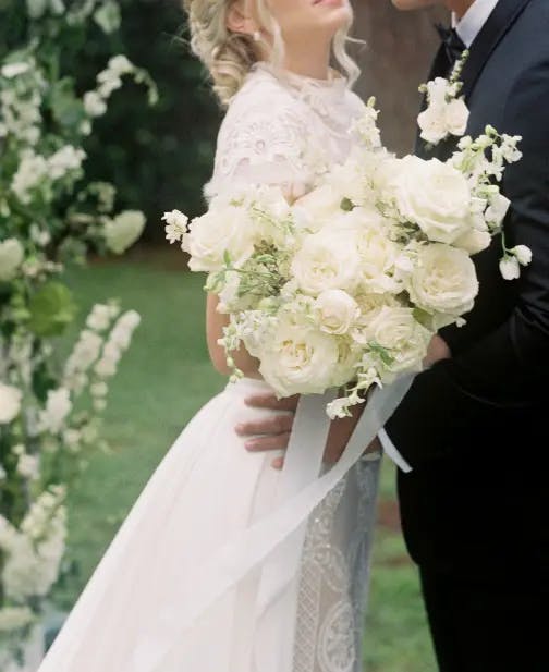 Chloe embrace behind white flowers