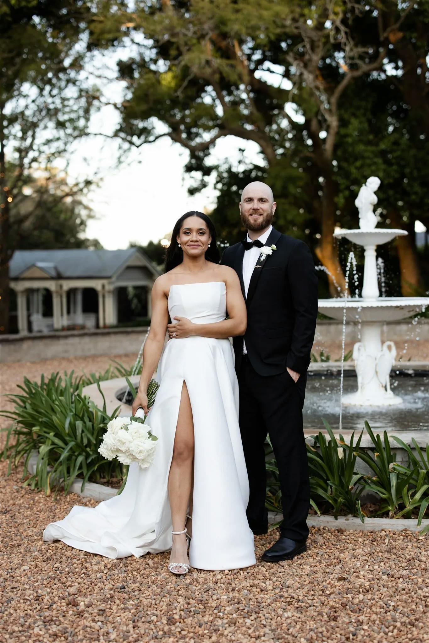 Bride and groom standing in front of fountain