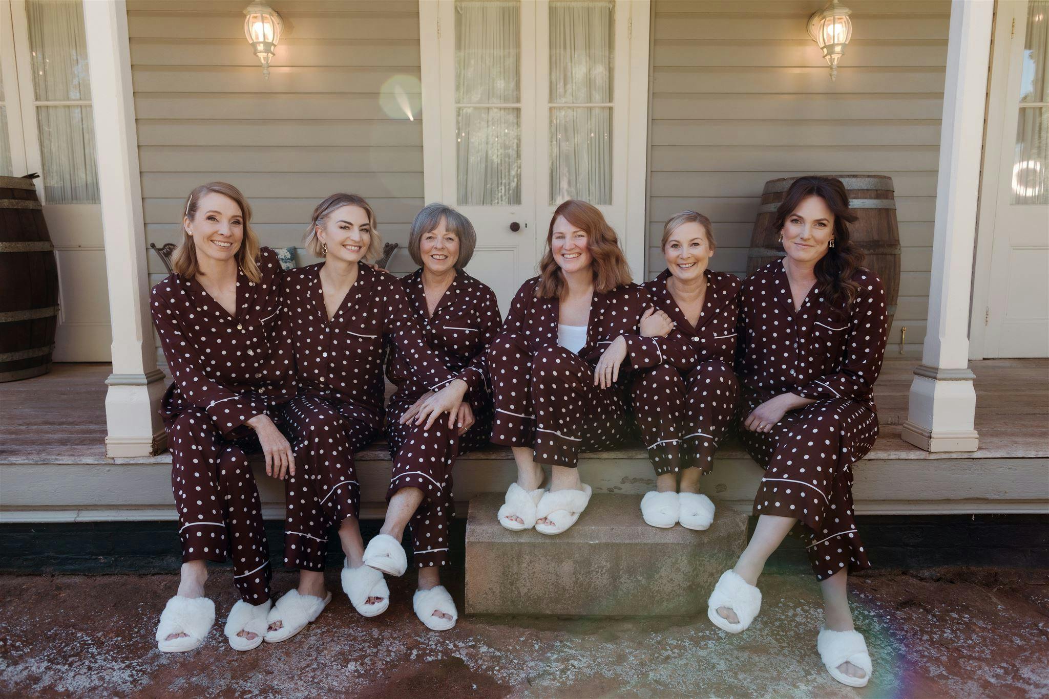 Bride and bridesmaids sitting on steps in pyjamas
