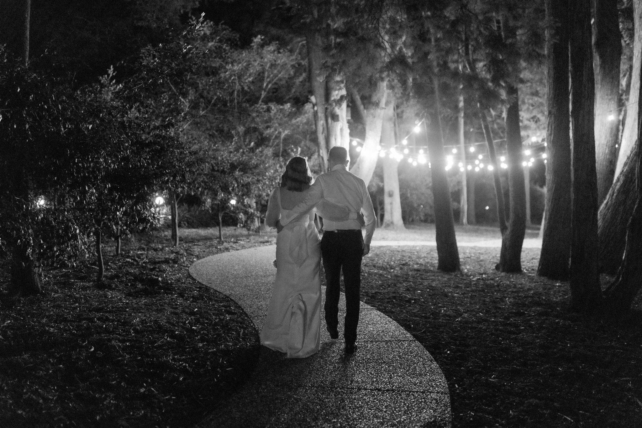 Bride and groom walking outside at night time