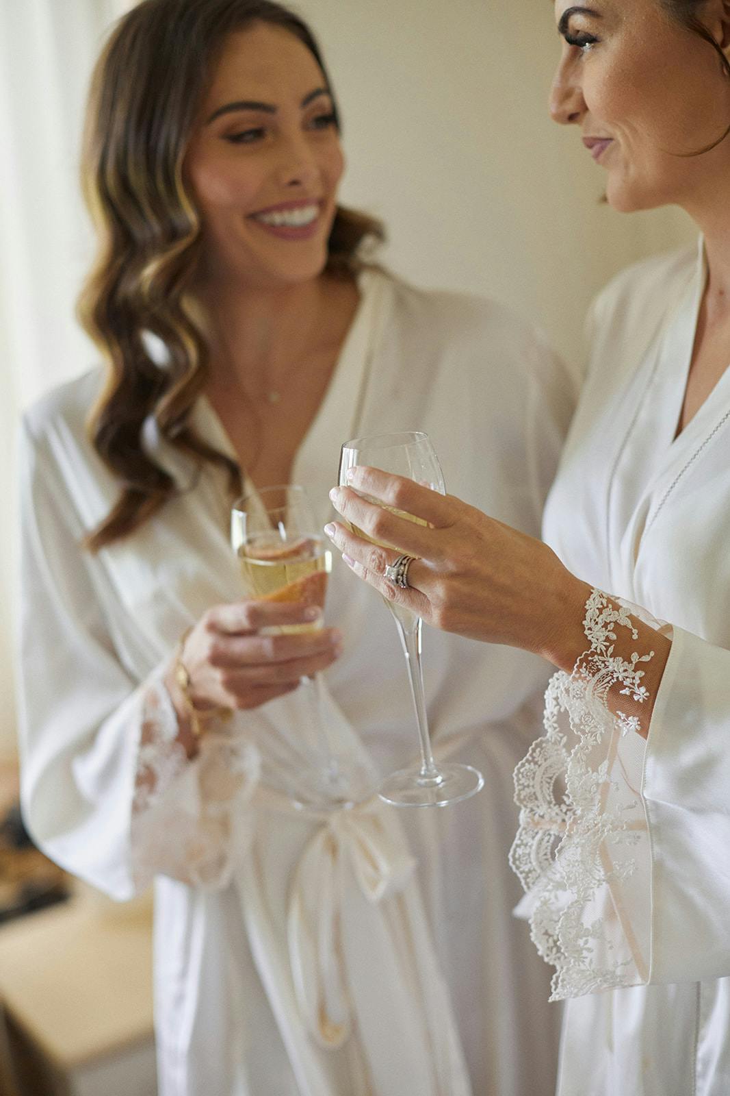 Bride and bridesmaid holding champagne glass