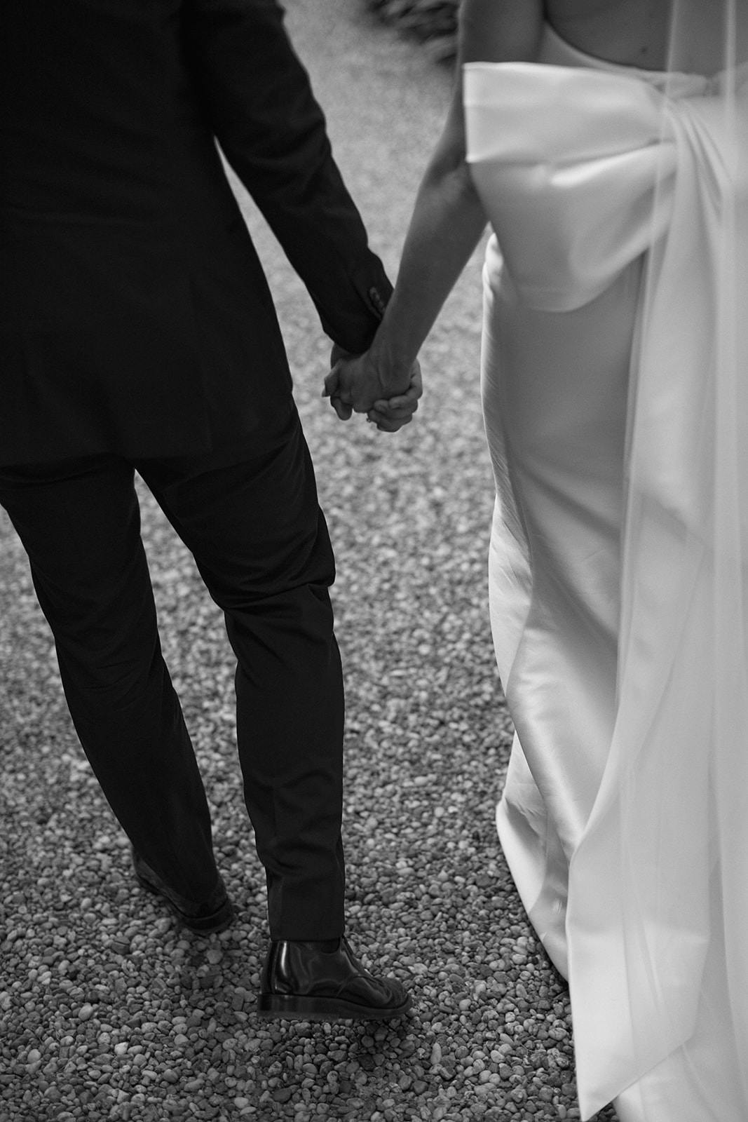 Bride and groom walking along holding hands