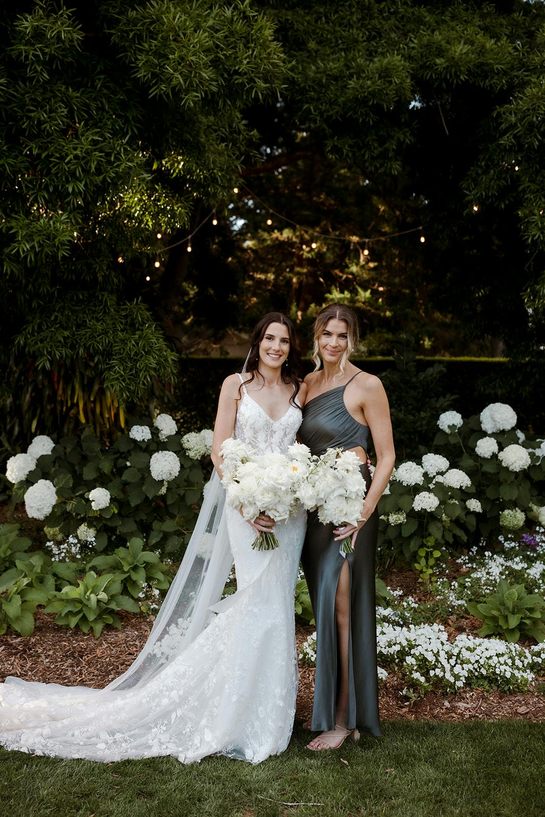 Bride and bridesmaids in front of flowers