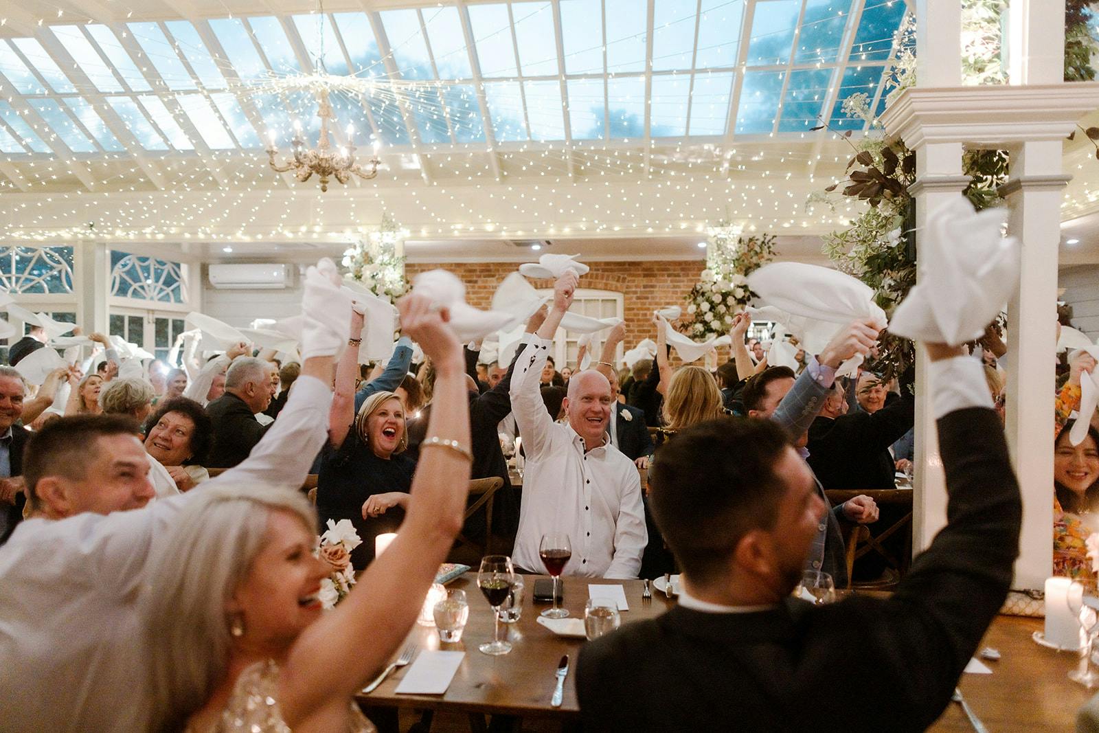 Guests waving napkins at wedding