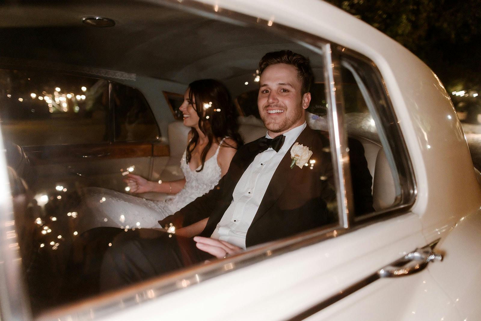 Bride and groom riding in wedding car