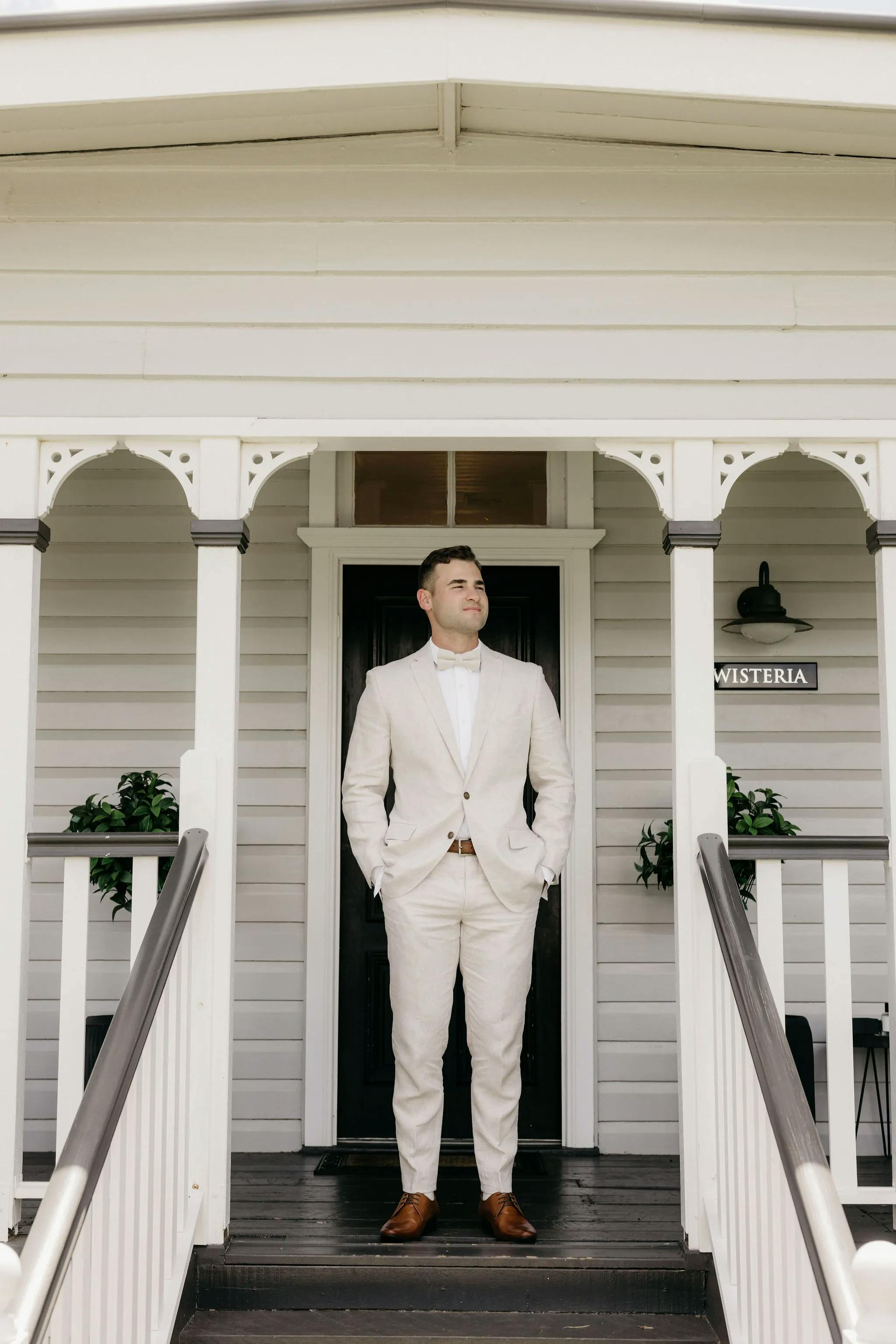 Man standing on steps at front of house