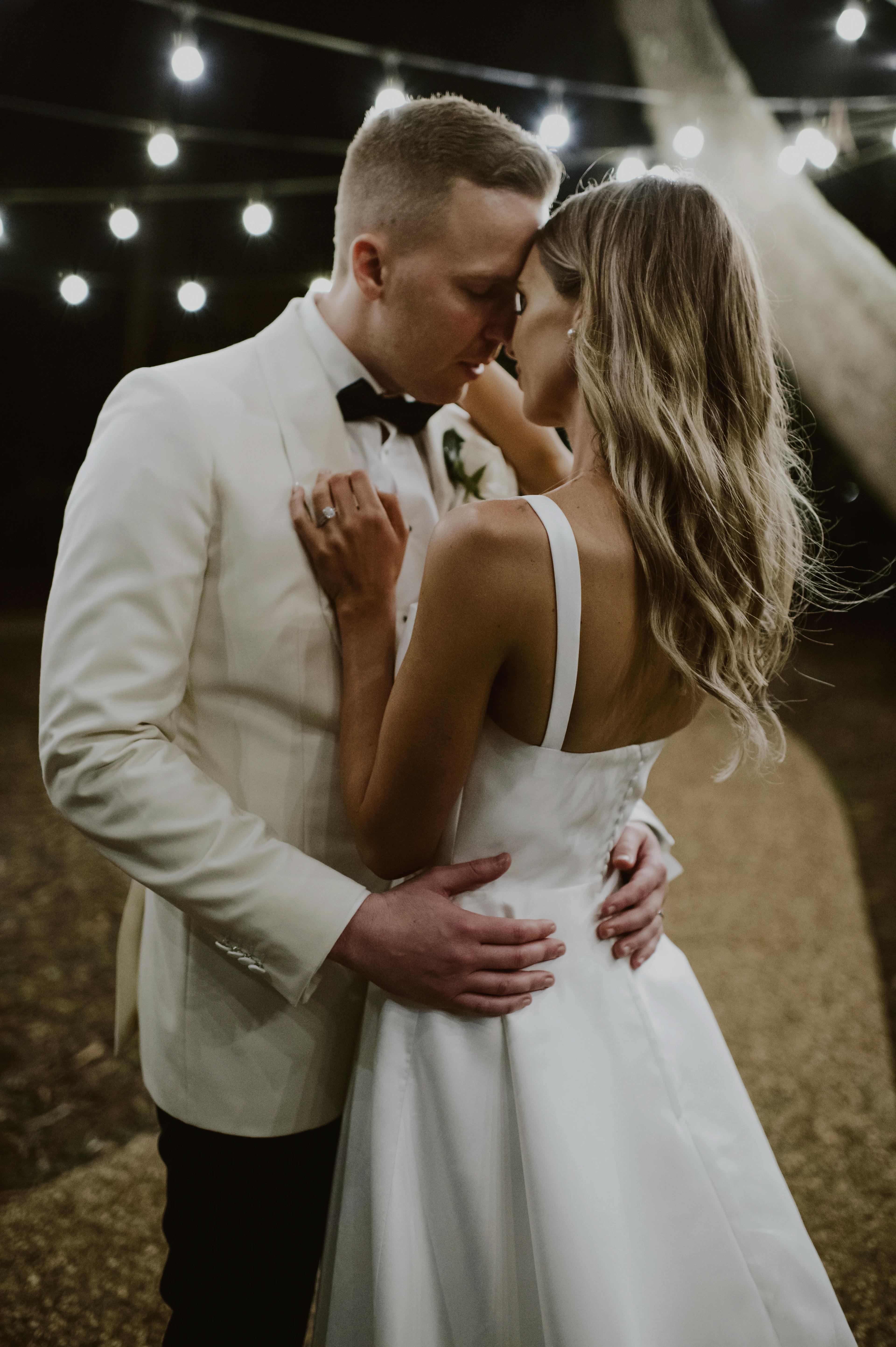 Couple kiss and dance under fairy lights