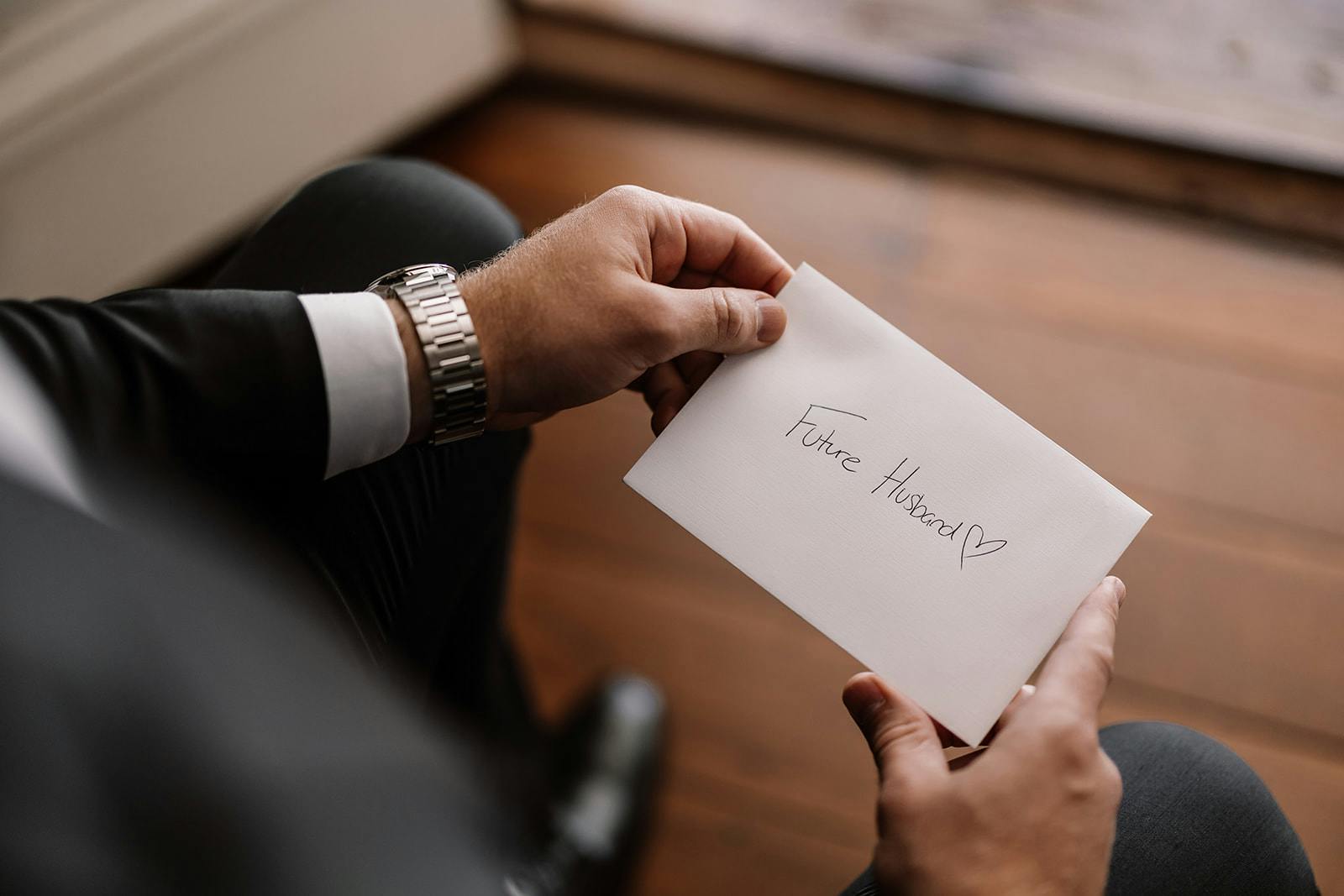 Groom holding card from wife