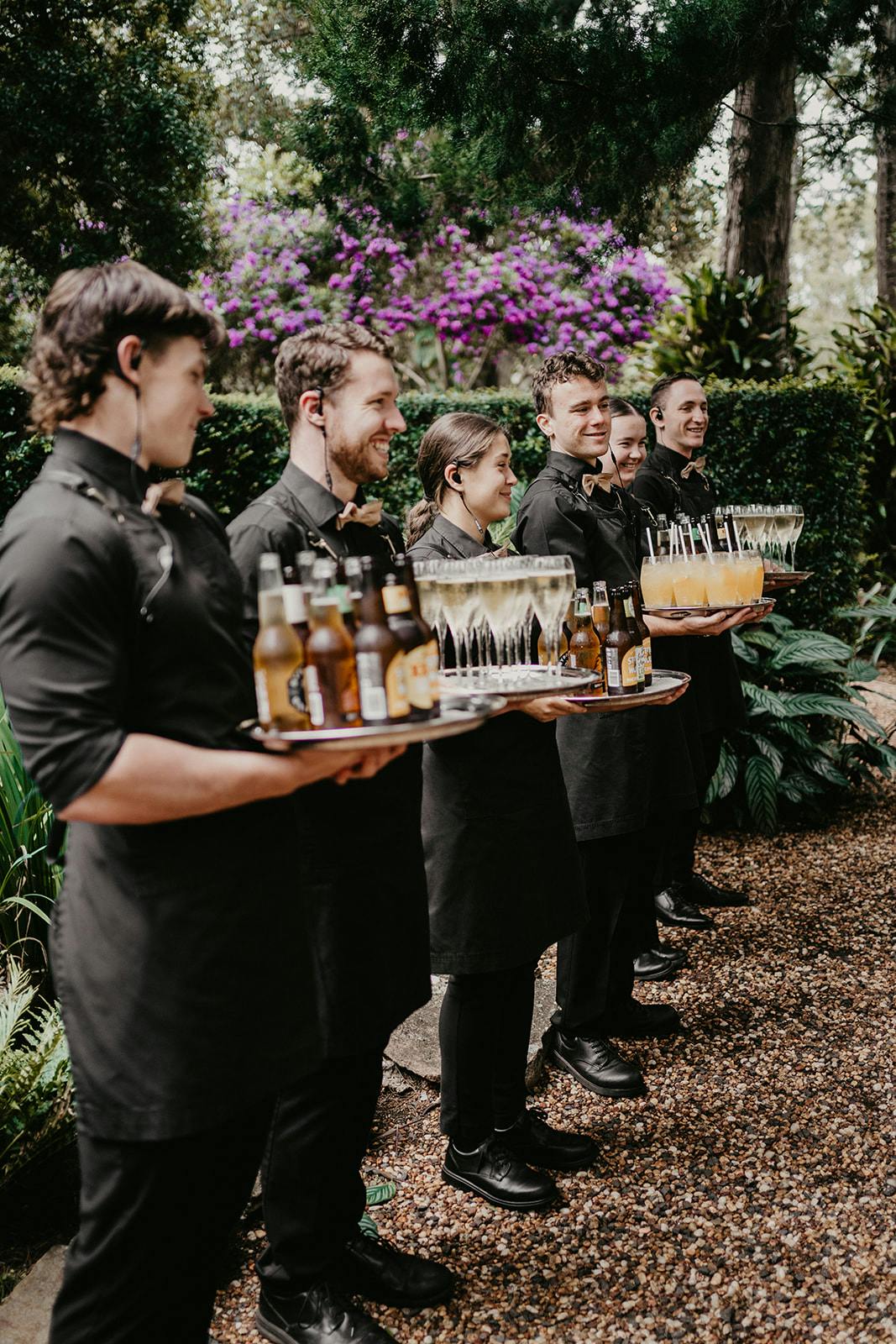 Waitstaff holding trays of drinks