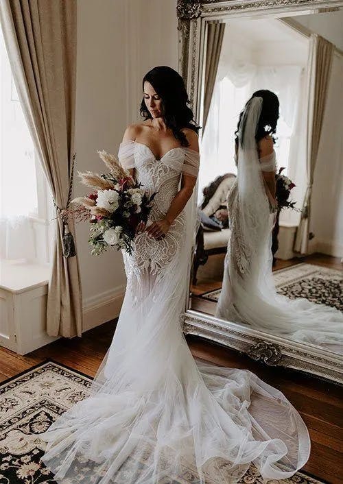 a beautiful bride posing for a photograph holding her wedding bouquet