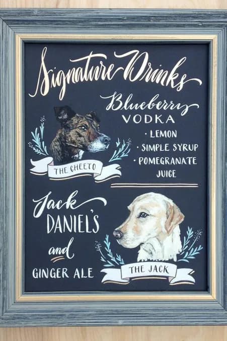 A chalkboard sign displays "Signature Drinks" menu. It features two drinks: "The Cheeto" with blueberry vodka, lemon, simple syrup, and pomegranate juice; and "The Jack" with Jack Daniel's and ginger ale. Illustrations of two dogs accompany each drink.