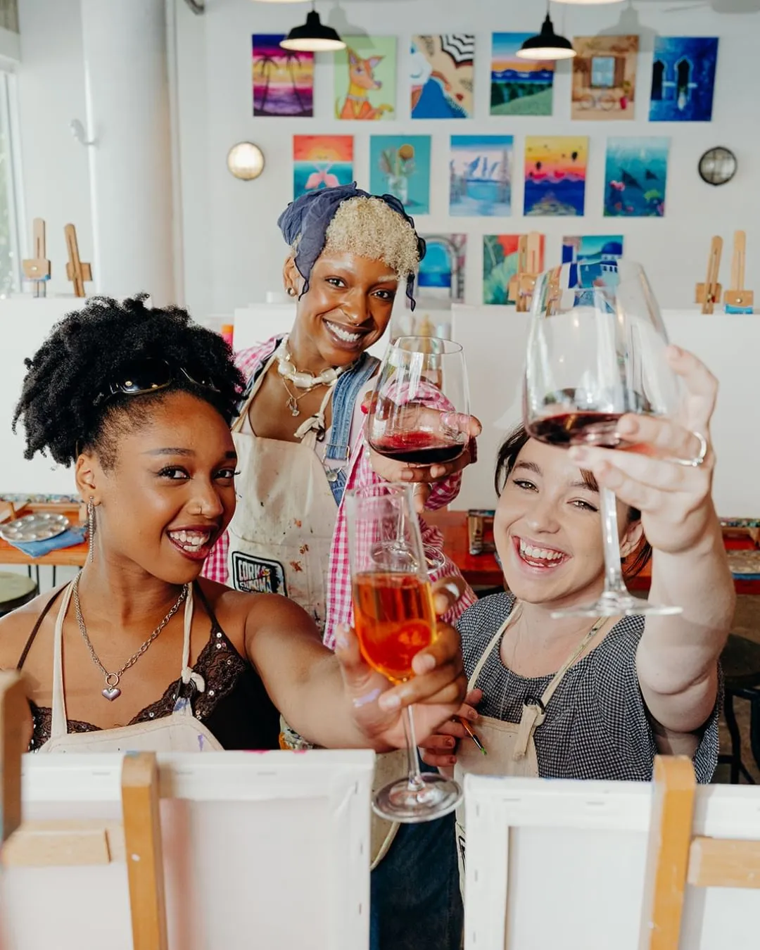 Women drinking wine and painting