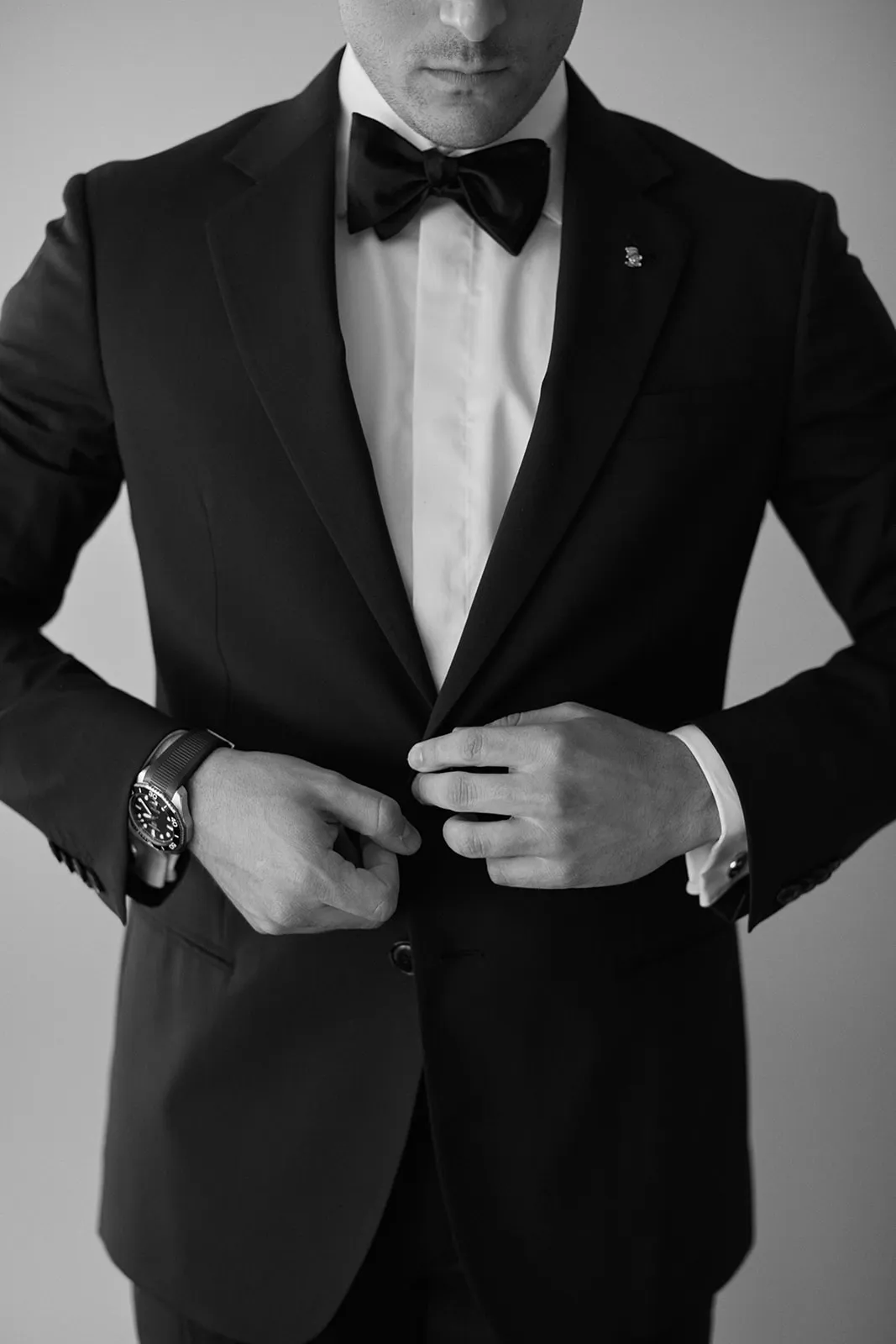 Groom buttoning up jacket