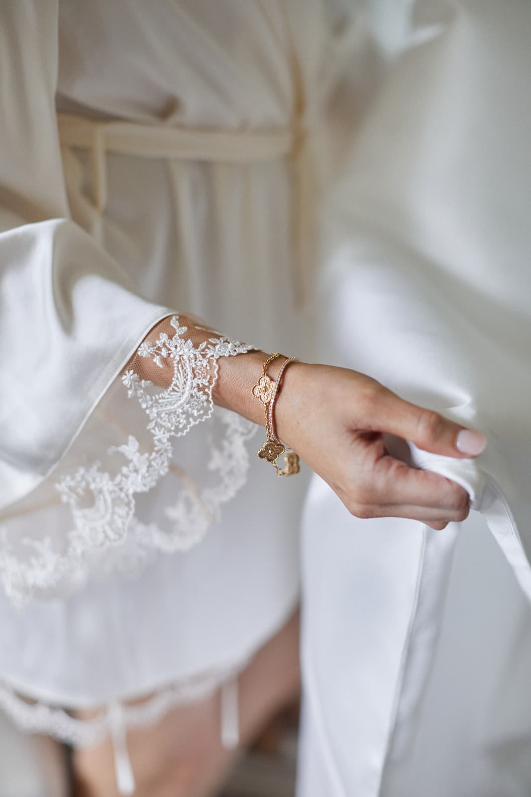 Bride wearing bracelet and holding wedding dress