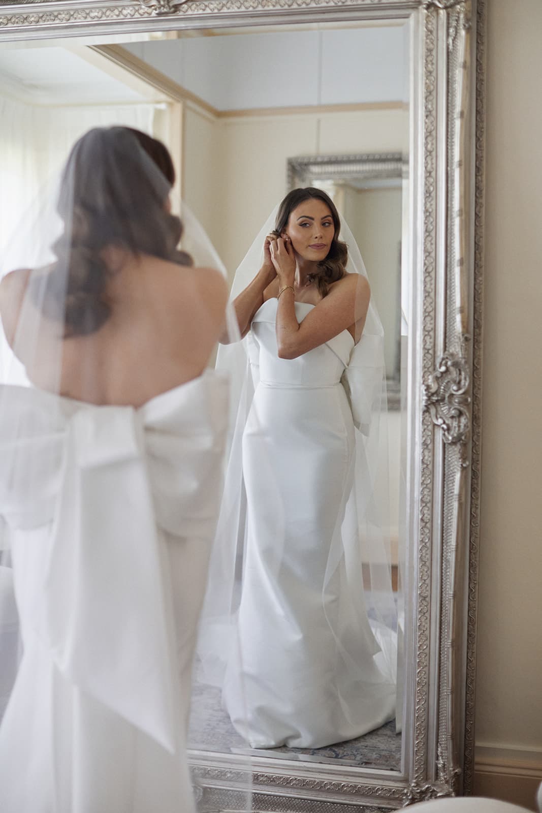 Bride putting earrings in