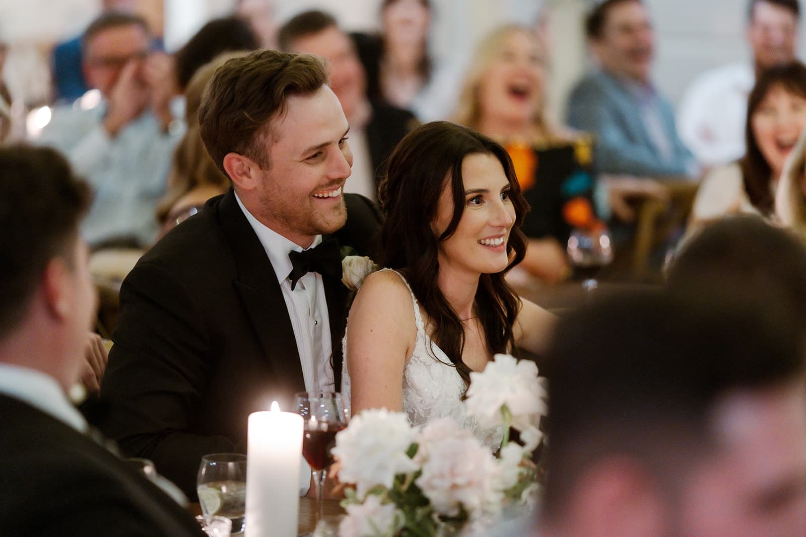 Bride and groom sitting amongst guests at wedding