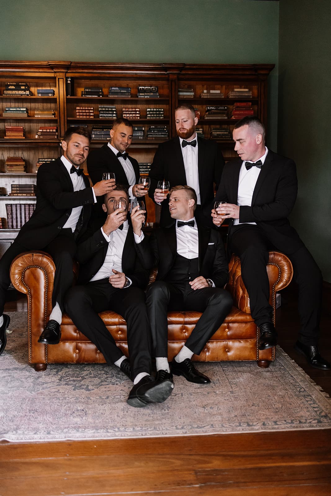Groom and groomsman sitting in leather couches