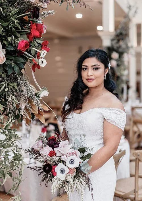 a beautiful bride posing for a photograph holding her wedding bouquet