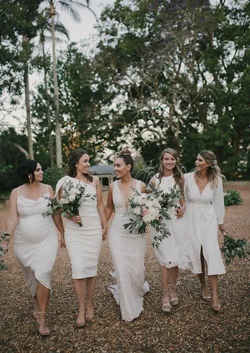 a beautiful bride and her bridesmaids walking through the grounds of gabbinbar